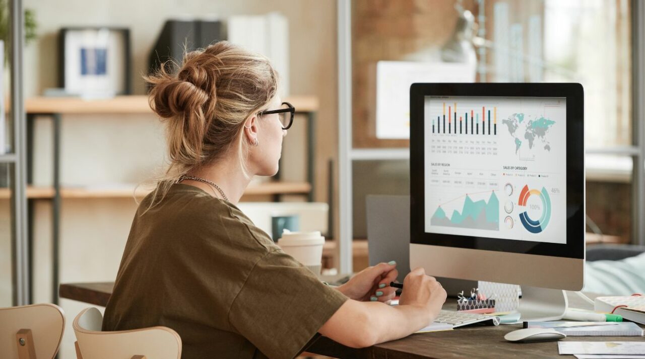 young woman wearing glasses checks computer looking for email marketers tools
