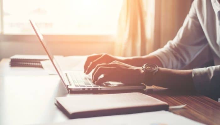 email marketing automation mistakes seen with a person sitting a desk with a laptop and typing. 