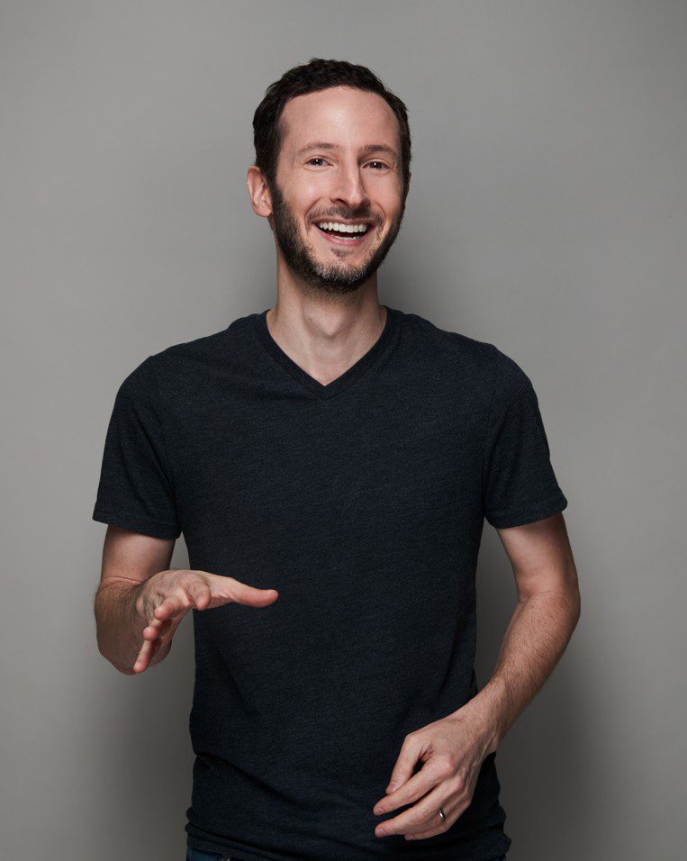 Entrepreneur magazine editor in chief Jason Feifer weating a black tshirt, smiling and gesticulating