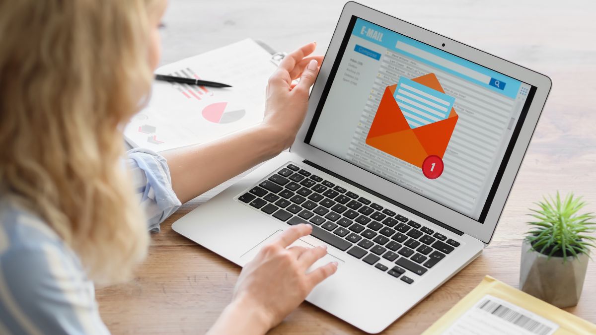 Woman sits before laptop after carefully planing a professional email signature.
