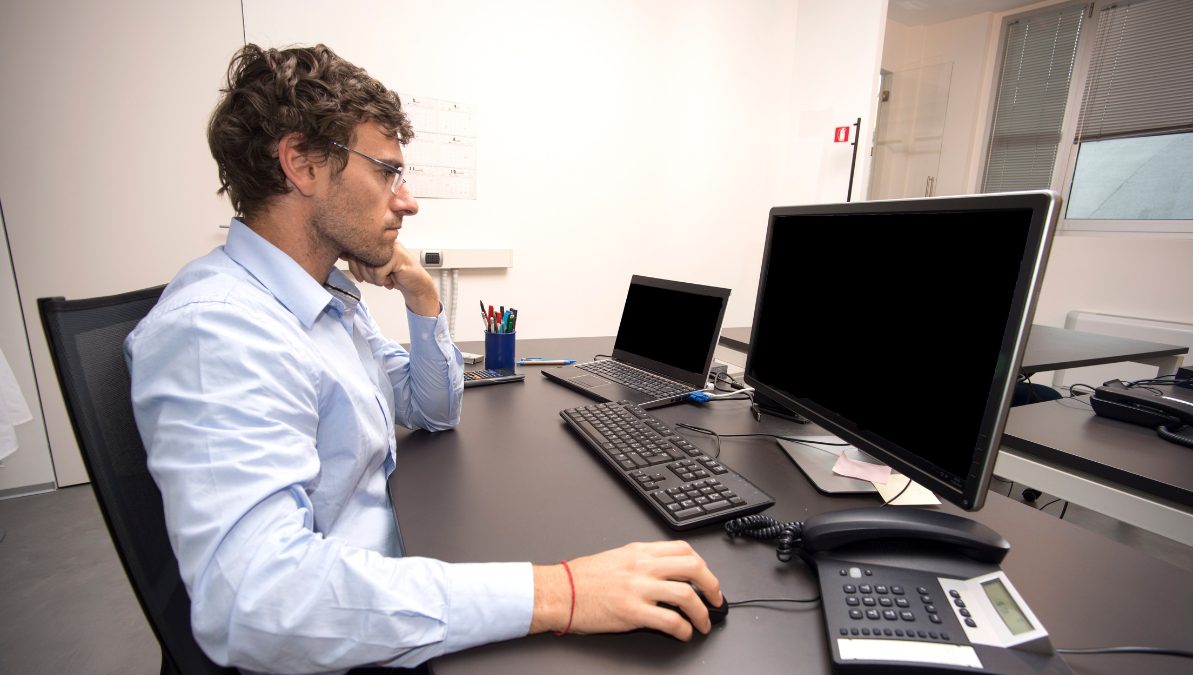 Bespectacled young man sits in front of his computer getting ready to use ZeroBounce with Bolt.new and Lovable.