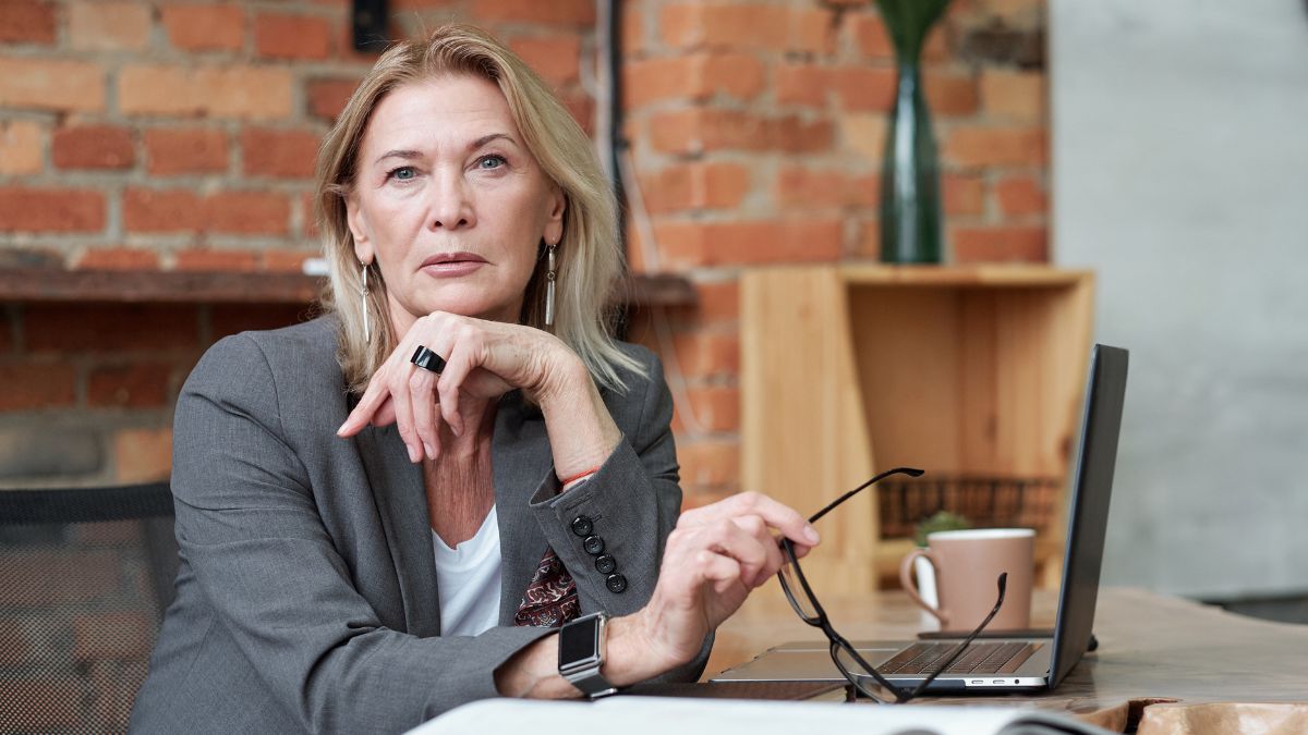 Decision-maker with blonde hair and eyeglasses removed considers reading email.